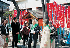 夢違え地蔵尊で参加者へ説明を行うガイドの星野ひろしさん（写真中央）